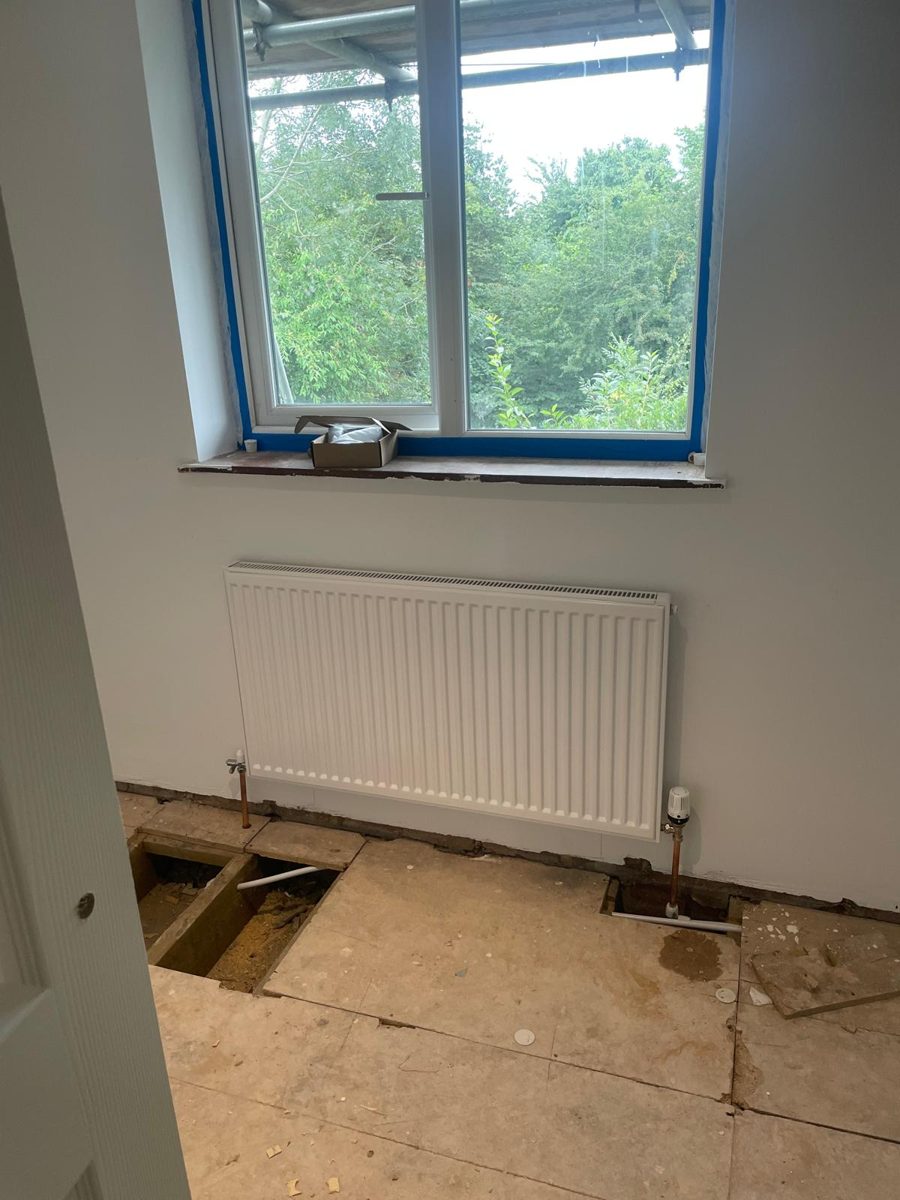 New white panel radiator fitted beneath a window